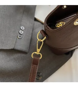 Detail of premium lychee grain leather bucket bag with glossy gold metal hardware
