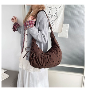 Sac fourre-tout marron à pois porté avec une tenue minimaliste dans un décor intérieur