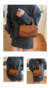 Detail of a brown quilted crossbody bag with top handle and adjustable silver buckle strap