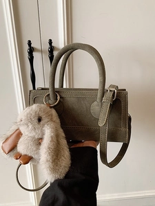 Fashionable dark green leather square handbag with plush bunny charm and adjustable strap