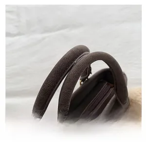 Close-up of brown vintage handbag featuring textured leather and a sturdy round handle