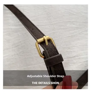 Macro shot of adjustable dark brown litchi leather strap with gold metal buckle