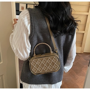 Rear view of a khaki quilted crossbody bag with white stitching and golden metal handles