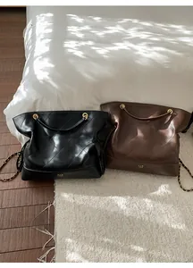 Detailed close-up of quilted leather tote bags in black and brown with chain straps
