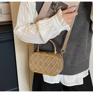 Detail of khaki leather oval box bag with quilted 'B' pattern and gold handle