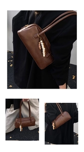 Detail of a retro dark brown leather cylinder bag with colorful beaded tassel charm