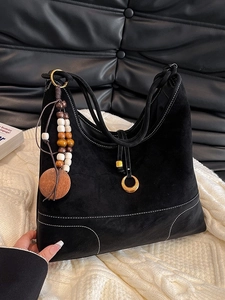 Minimalist black suede and leather patchwork shoulder bag with ethnic wooden bead pendant