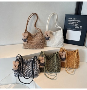Détail de cinq sacs seaux en laine bouclée de couleurs variées avec breloque ours