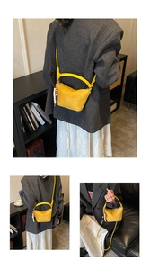 Detalle del bolso de cubo amarillo con colgante de madera y asa redonda para mujer