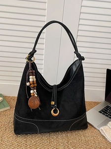 Black suede hobo shoulder bag with wooden bead charm and contrast stitching