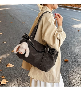 Matte dark brown oversized tote bag with adjustable straps and a cute plush rabbit charm