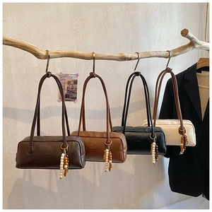 Detail of four retro underarm bags in brown and black with unique beaded bag charms