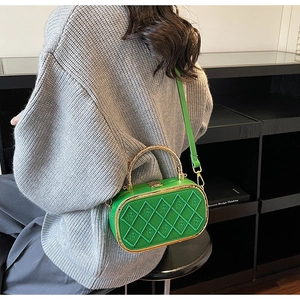 Macro shot of green leather box bag with diamond stitching and golden hardware