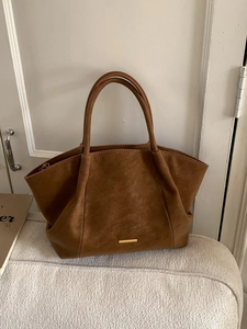 Brown faux leather tote bag with gold hardware and top handles for commuting