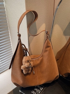Brown suede hobo tote bag with teddy bear charm and adjustable shoulder strap