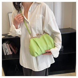 Detail of lime green pleated cloud bag featuring a vintage metal clasp and rhinestones