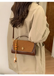 Brown retro crossbody bag featuring contrast textures, gold clasp and beaded tassel detail
