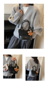 Detail of black bucket bag with plush bear charm and premium mixed leather textures