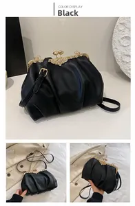 Detail of black pleated cloud bag with rhinestone floral clasp and gold frame