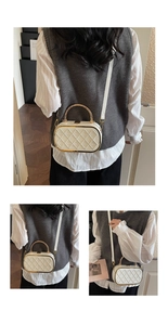 Detail of cream quilted crossbody bag with gold handle and embossed B patterns