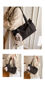 Detail of vintage matte tote bag in dark brown with fuzzy rabbit charm and metal buckle