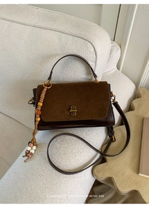 Macro detail of dark brown retro crossbody bag with suede拼接 and gold twist lock closure
