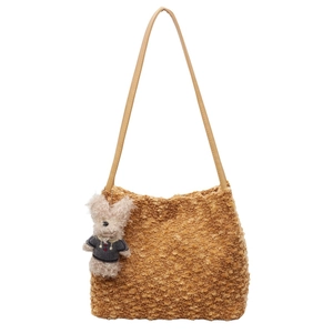 Detailed texture of brown plush tote bag featuring a cute teddy bear charm and strap
