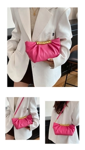 Detail of pink pleated clutch bag with golden spiral handle and slim shoulder strap