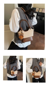 Detail of vintage beige and brown bucket bag with plush bear charm and crossbody strap