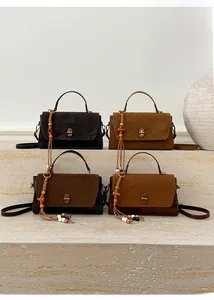 Detail of vintage suede handbags with gold hardware and beaded tassel charms