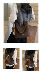 Detail of dark brown faux suede tote bag featuring gold lettering and cute bear charm