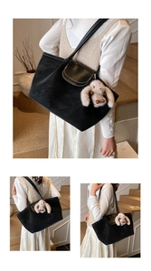 Detail of black tote bag with white stitching and cute plush bunny charm accessory