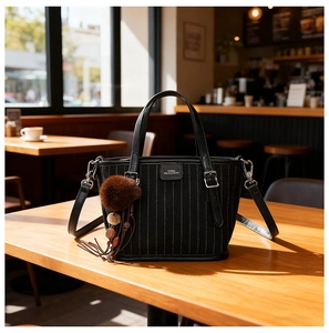 Détails du sac cabas noir à rayures avec charm en peluche et surpiqûres blanches fines