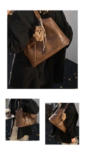 Close-up of brown leather bucket bag with dog plush pendant and drawstring details
