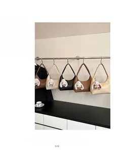 Hobo bags in five classic colors with plush bunny charms on a display rack