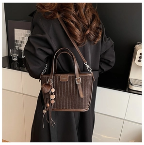 Détail du sac cabas marron vintage avec charm en peluche et glands perlés