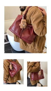 Detail of wine red faux leather tote bag with cute brown teddy bear plush charm