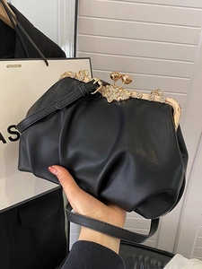 Black ruched leather cloud bag with gold floral clasp and crossbody strap for women