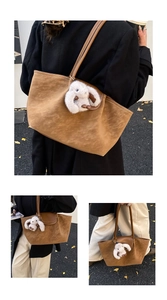 Close-up of brown suede hobo bag with white plush bunny charm and silver ginkgo leaves