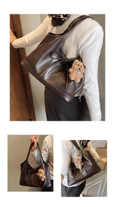 Detail view of large dark brown tote bag with matte leather finish and bear charm