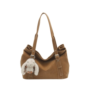 Brown matte tote bag with thin shoulder strap and a cute grey rabbit plush charm accessory