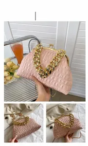 Macro detail of pink pleated PU leather handbag with vintage gold metal clasp and thick chain