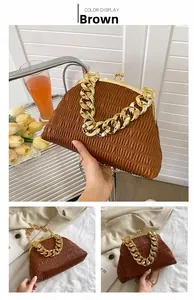 Detail of dark brown pleated clutch featuring thick gold chain handle and metal clasp