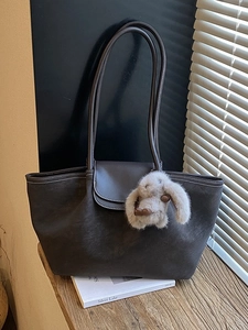 Retro deep brown leather tote bag with white contrast stitching and plush rabbit charm