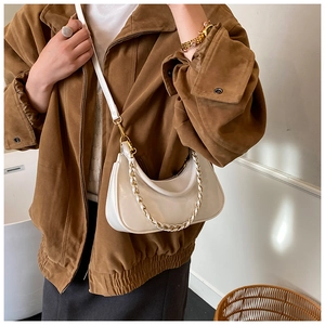 Detail of white half-moon bag featuring gold chain strap and smooth leather texture