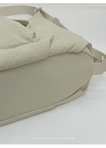 Gros plan du sac fourre-tout plissé beige montrant la texture en nylon et le design