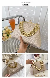 Detailed view of khaki pleated dumpling bag with chunky gold chain and metallic buckle