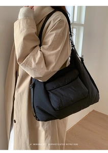 Side view of black canvas tote bag with flap pocket and adjustable strap on a model