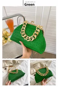Detail of green pleated dumpling bag with chunky gold chain strap and metal clasp closure