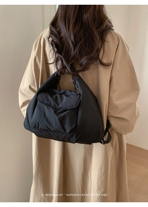 Détail d'un grand sac bandoulière noir avec texture matelassée sur un mannequin